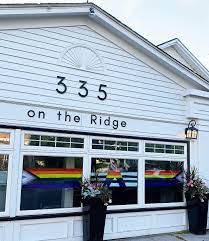 White walls, restaurant, rainbow flag on the windows, plants in tall pots, Niagara ON restaurants